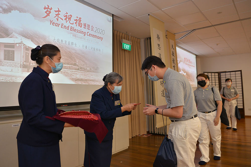 志工恭敬地接过来自台湾证严上人赠予的福慧红包，接受满满的祝福。（摄 / 蔡佑良）