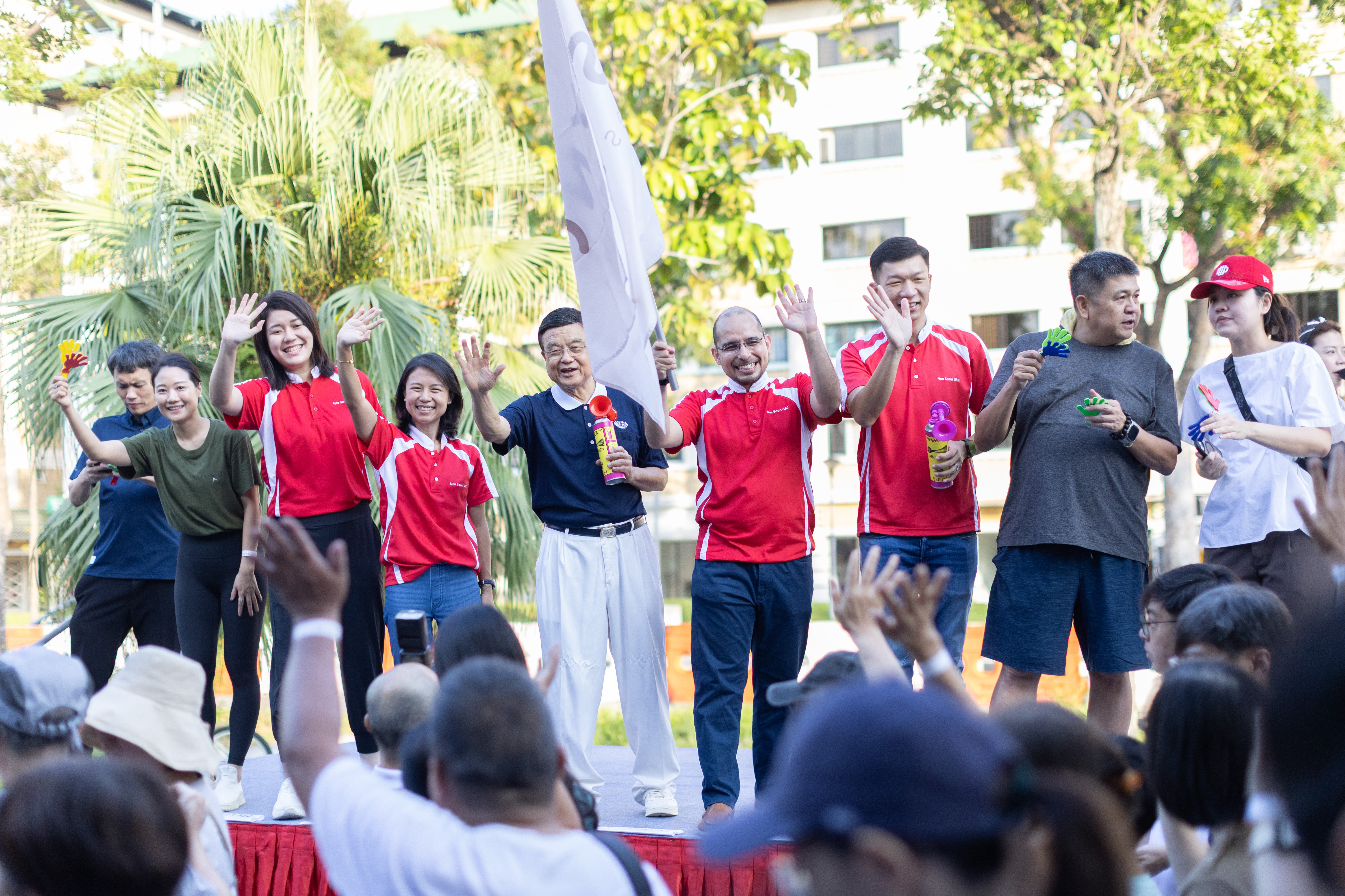 Senior Parliamentary Secretary for the Ministry of Sustainability and the Environment & the Ministry of Culture, Community and Youth, Ms Goh Han Yan (fourth from left), Member of Parliament for Nee Soon GRC, Dr Syed Harun Alhabsyi (fourth from right in red), Mr Jackson Lam (third from right), Ms Lee Hui Ying (third from left), Tzu-Chi Foundation (Singapore) CEO Low Swee Seh and representatives of the donating companies waving the flag to start the Fam Walk. (Photo by Donn Tan))